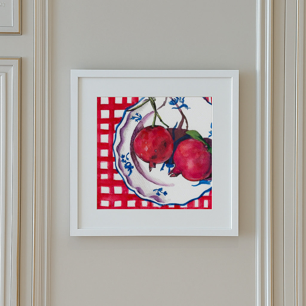 Framed original watercolour painting titled “Seeds of Hope (Pomegranates)” by Shanaz Minhas, featuring two softly painted pomegranates in warm, delicate tones.