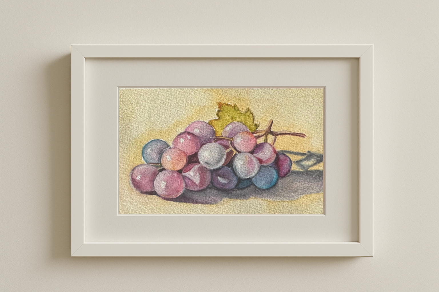 Framed original watercolour painting titled “Grapes in Light” by Shanaz Minhas, featuring soft purple hues and gentle light capturing the stillness of fruit.
