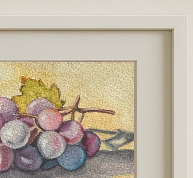Grapes in Light” framed and displayed on a neutral wall, adding a soft, contemplative presence to the space.